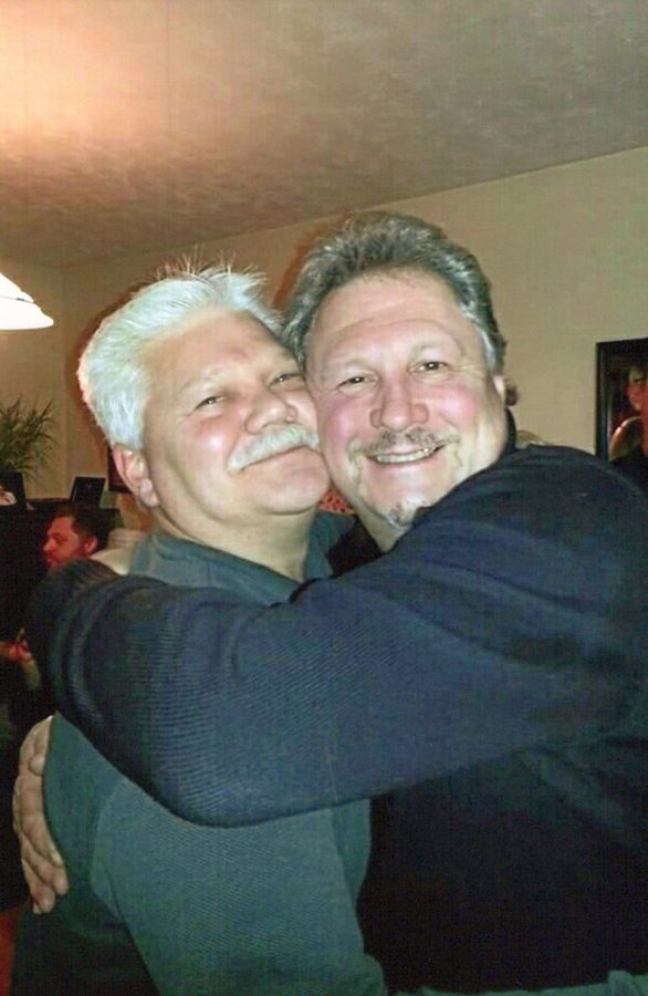 Mike, gray-haired and smiling, hugging a friend